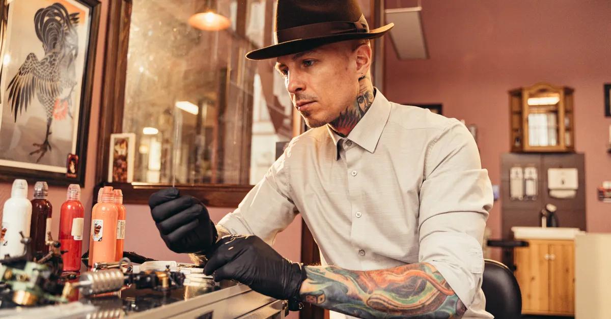 A tattoo artist in the studio preparing ink and equipment at his workstation